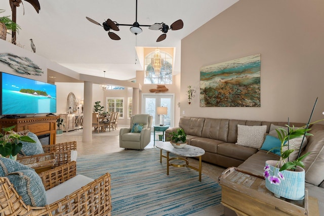 living room featuring tile patterned flooring, ceiling fan with notable chandelier, and high vaulted ceiling