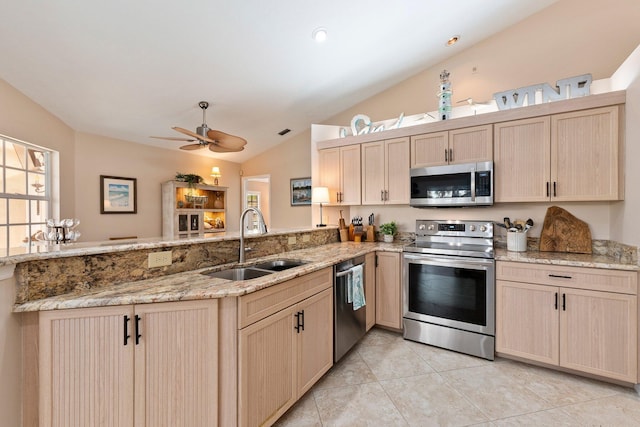 kitchen featuring lofted ceiling, sink, light brown cabinetry, kitchen peninsula, and stainless steel appliances