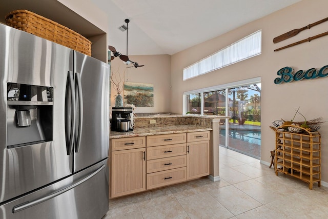 kitchen with light brown cabinets, light stone counters, and stainless steel fridge with ice dispenser