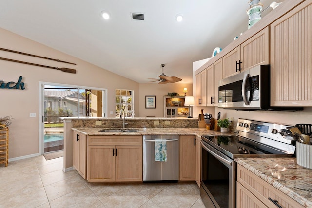 kitchen with kitchen peninsula, sink, light brown cabinetry, and appliances with stainless steel finishes