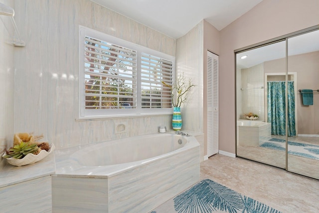 bathroom featuring a relaxing tiled tub and vaulted ceiling