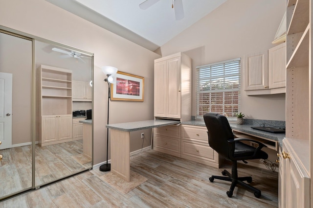 home office with built in desk, light hardwood / wood-style floors, and vaulted ceiling