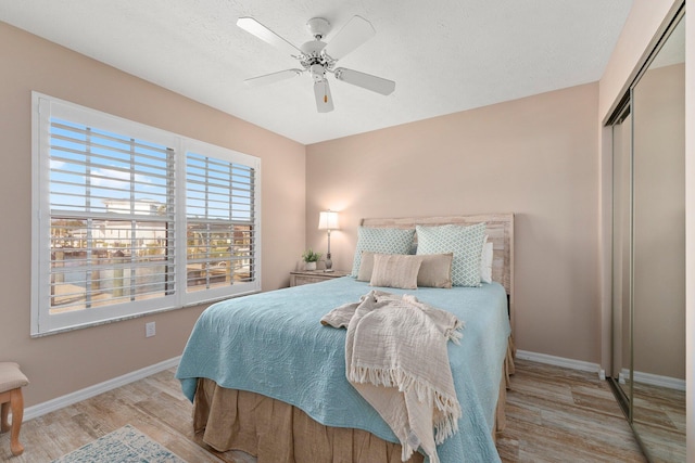 bedroom featuring ceiling fan, light hardwood / wood-style floors, and a closet