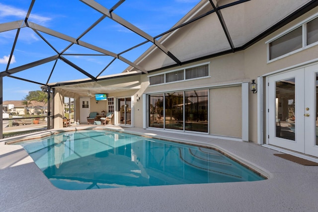 view of swimming pool with a patio area, a lanai, and french doors