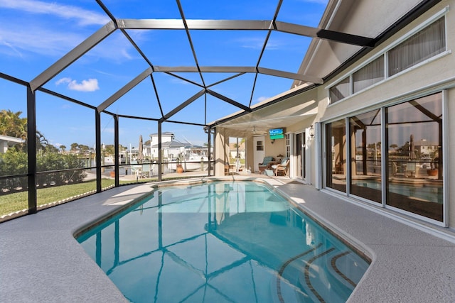 view of pool with a lanai, ceiling fan, and a patio area