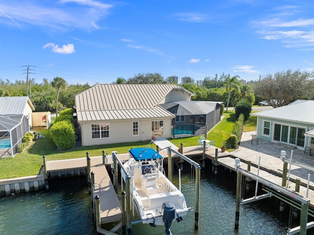 dock area with glass enclosure, a yard, a patio area, a swimming pool, and a water view