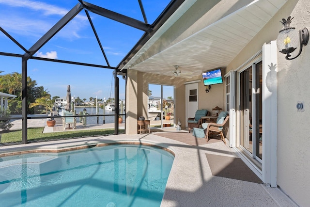 view of swimming pool with ceiling fan, a lanai, and a patio