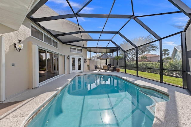 view of swimming pool featuring a lanai, a patio area, and french doors