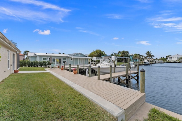 view of dock with a yard and a water view