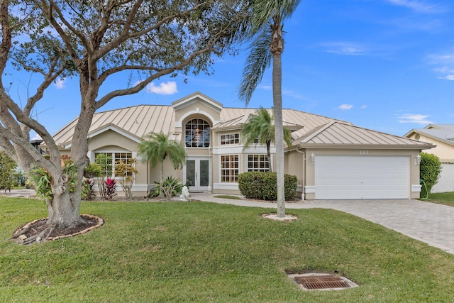 view of front of property featuring french doors, a front yard, and a garage