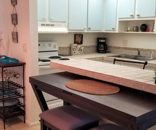 kitchen featuring white cabinets, white range with electric stovetop, exhaust hood, and tile countertops