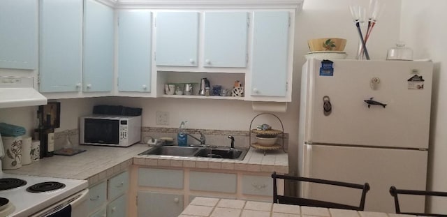 kitchen with white cabinets, tile counters, white appliances, and sink