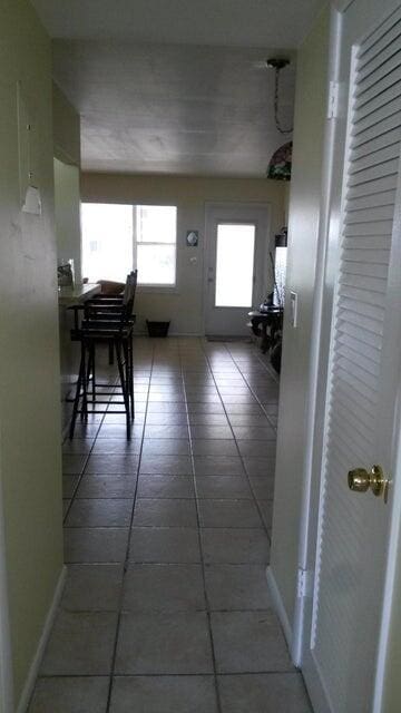 hall featuring dark tile patterned flooring