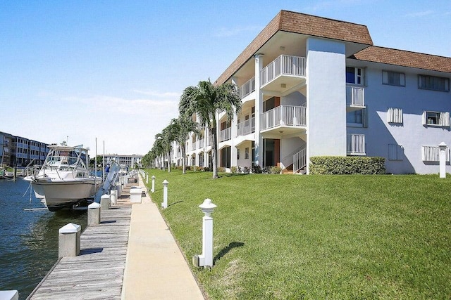 view of dock with a yard and a water view