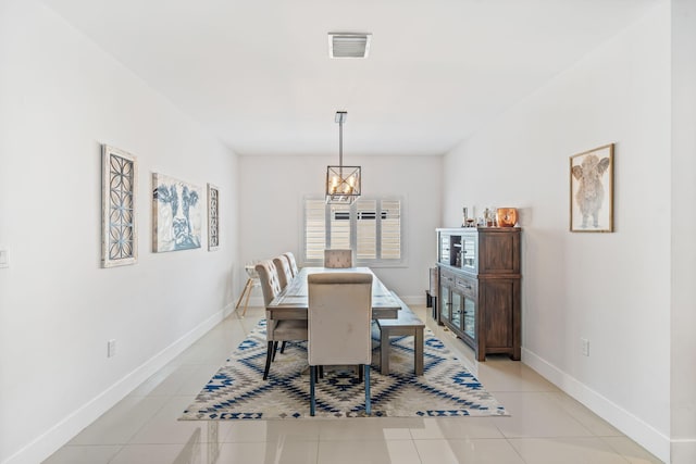 tiled dining space featuring a notable chandelier