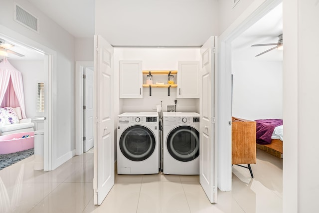 laundry area featuring washing machine and clothes dryer, ceiling fan, light tile patterned floors, and cabinets