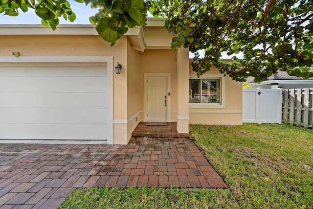 doorway to property featuring a lawn and a garage