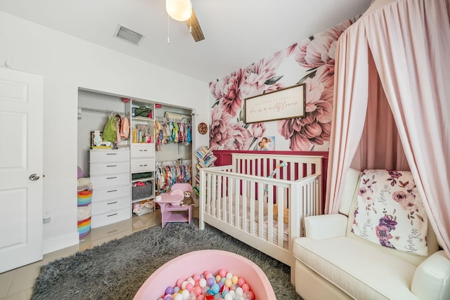 bedroom featuring ceiling fan, a closet, and a nursery area