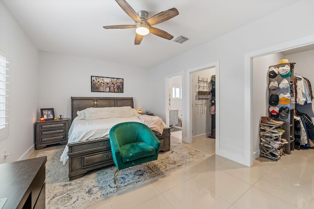 bedroom with connected bathroom, a spacious closet, ceiling fan, and light tile patterned flooring