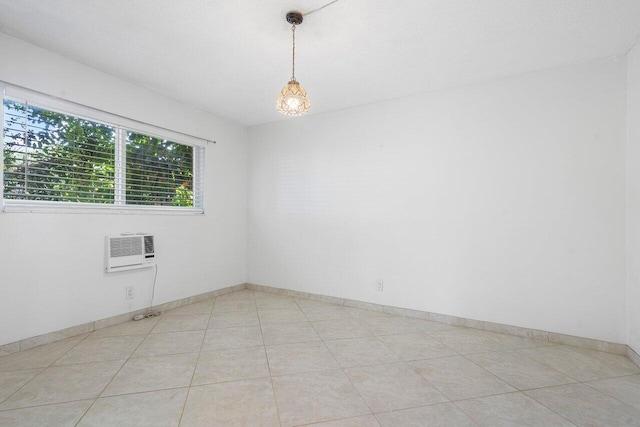 spare room with a wall unit AC and light tile patterned floors