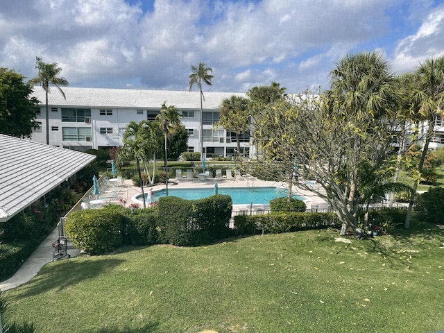 view of swimming pool with a yard