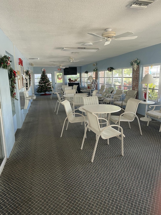 dining space featuring a textured ceiling and ceiling fan