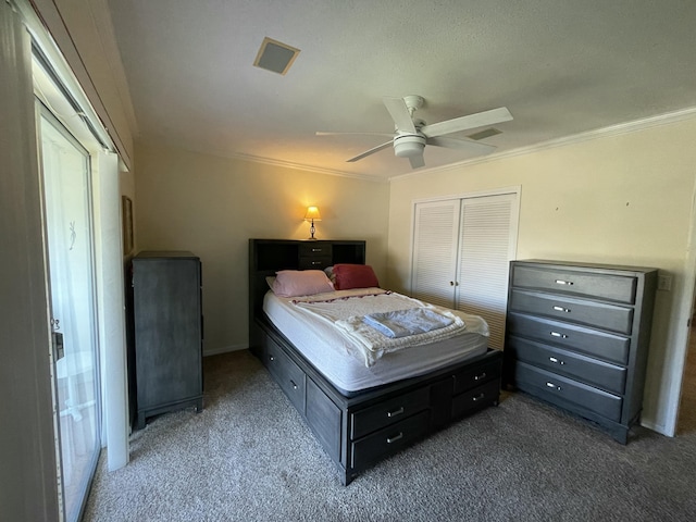 carpeted bedroom with ceiling fan, a closet, and ornamental molding