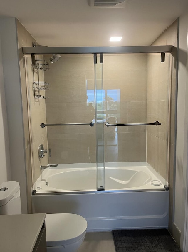 full bathroom featuring shower / bath combination with glass door, tile patterned flooring, toilet, and vanity