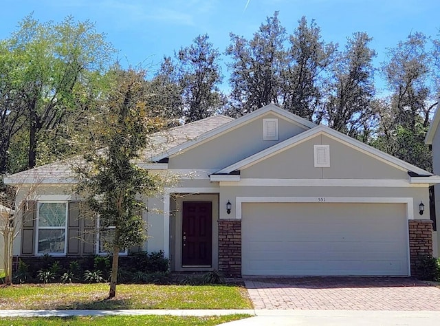 ranch-style home with a garage and a front lawn