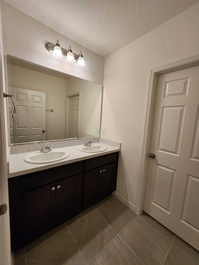 bathroom featuring vanity, tile patterned flooring, and a textured ceiling