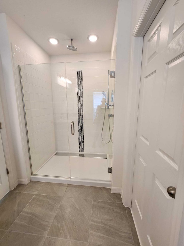 bathroom featuring tile patterned floors and a shower with shower door