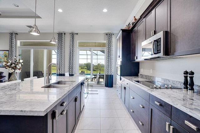 kitchen featuring pendant lighting, a kitchen island with sink, crown molding, sink, and stainless steel appliances