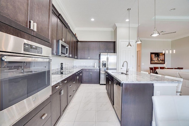 kitchen with sink, hanging light fixtures, stainless steel appliances, dark brown cabinets, and ornamental molding