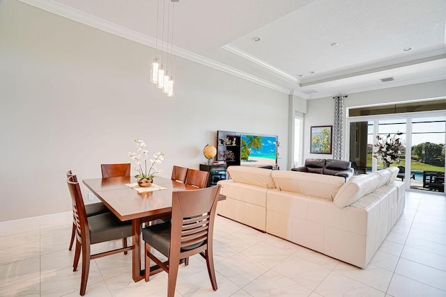 tiled dining space with a raised ceiling and crown molding