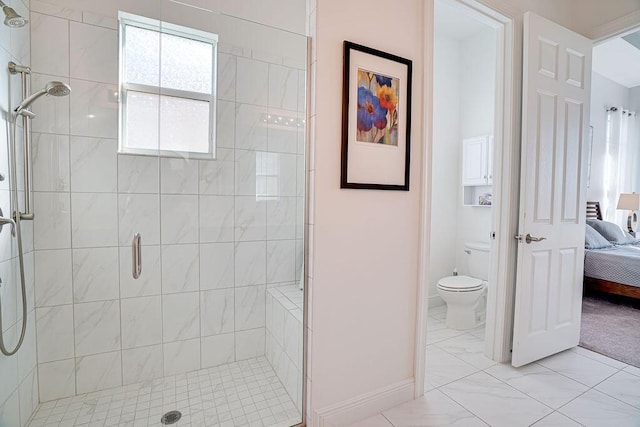 bathroom with toilet and a shower with door