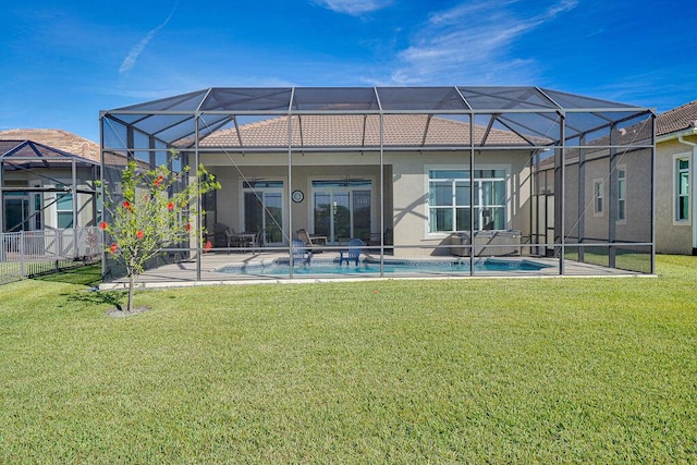 back of house with glass enclosure and a yard