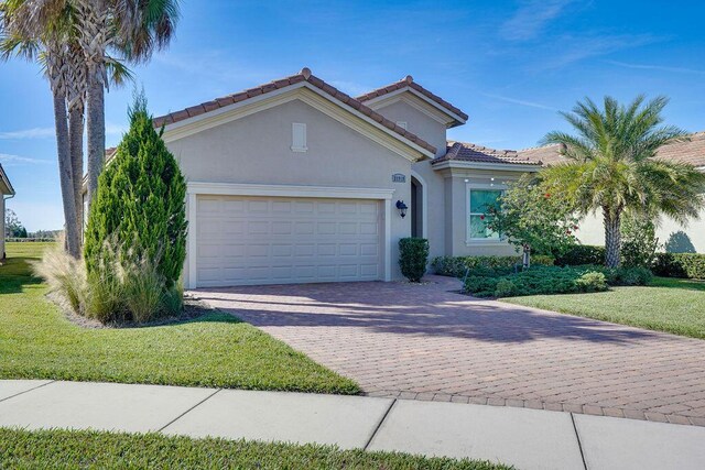 mediterranean / spanish house with a front yard and a garage