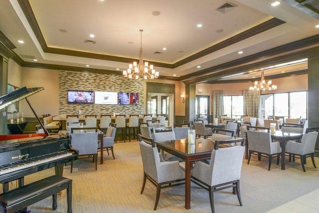 dining area featuring ornamental molding, a tray ceiling, and an inviting chandelier