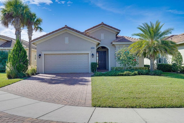 mediterranean / spanish-style home featuring a garage and a front lawn