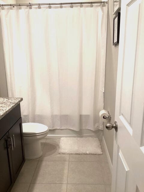 full bathroom featuring tile patterned flooring, vanity, toilet, and shower / tub combo with curtain