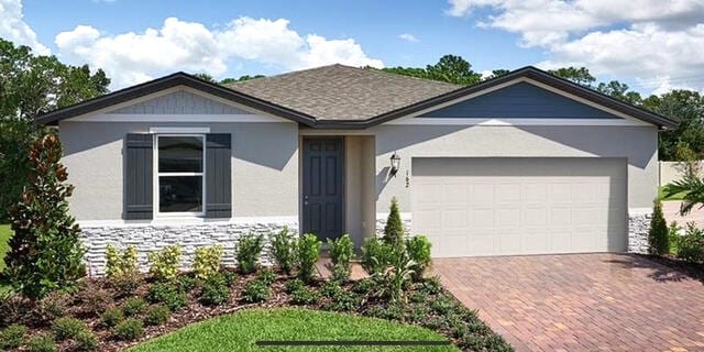 162 Andreas St, Winter Haven, FL 33881 - ranch-style house with a garage, decorative driveway, stucco siding, and stone siding