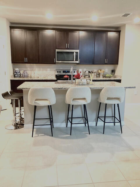 kitchen featuring a breakfast bar, light tile patterned floors, and stainless steel appliances