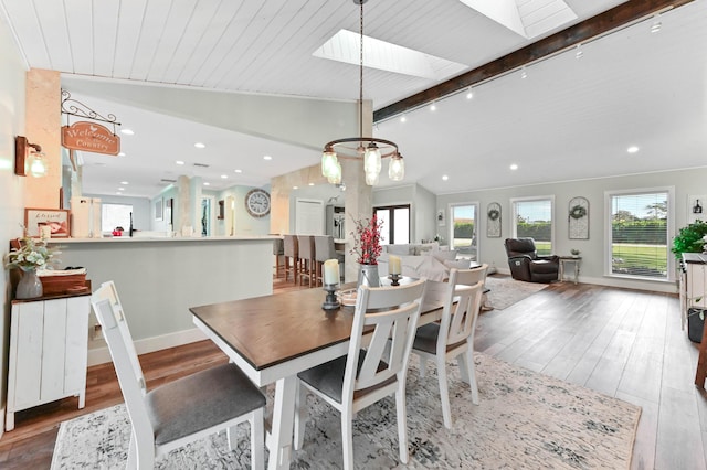 dining area with hardwood / wood-style floors, plenty of natural light, lofted ceiling with skylight, and wooden ceiling