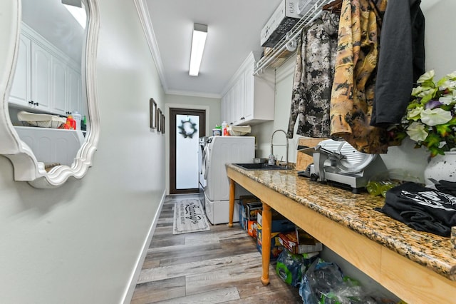 kitchen featuring crown molding, white cabinetry, hardwood / wood-style floors, independent washer and dryer, and light stone counters