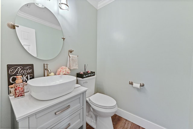 bathroom with vanity, ornamental molding, hardwood / wood-style floors, and toilet