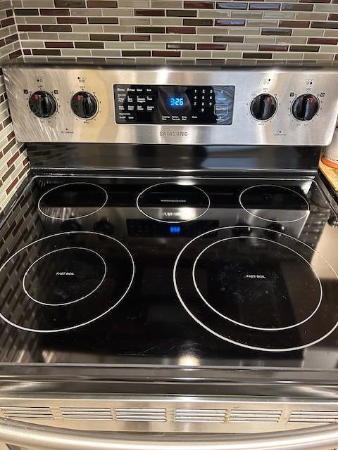 room details featuring backsplash and stainless steel range with electric cooktop