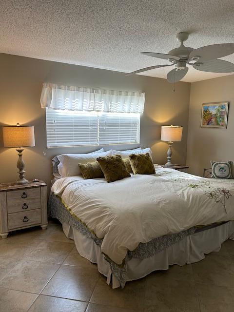 tiled bedroom featuring a textured ceiling and ceiling fan