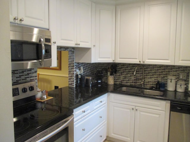 kitchen with white cabinetry, stainless steel appliances, sink, and tasteful backsplash