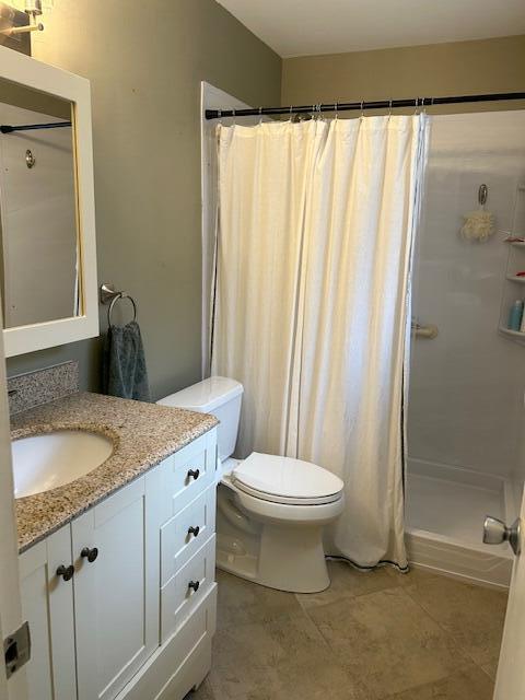 bathroom featuring vanity, curtained shower, and toilet