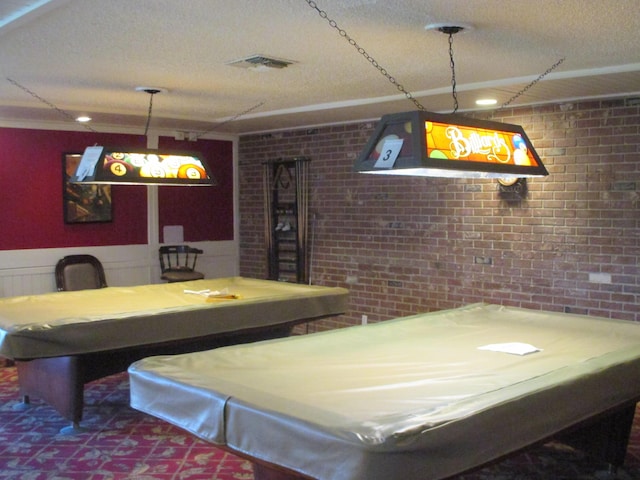 rec room featuring pool table, brick wall, and a textured ceiling